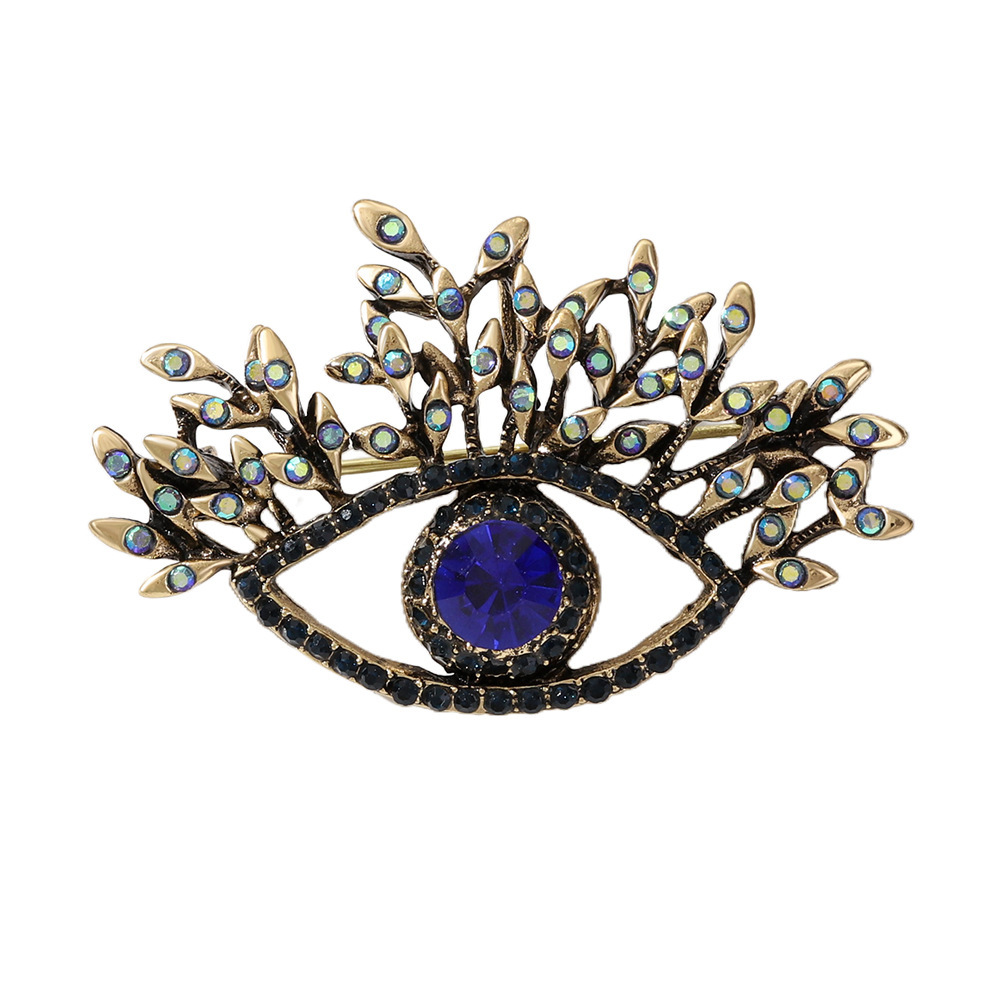 Broche vintage luxueuse et élégante haut de gamme, ornée de longs cils et d'un regard démoniaque, mettant en valeur une personnalité unique et exacerbée._voghion.com