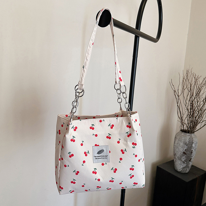 Moda pequeña y fresca impresión de cereza bolsos de invierno 2025, bolsos de mujer nuevos, bolsos de gran capacidad, bolsos de mujer de estilo exterior.