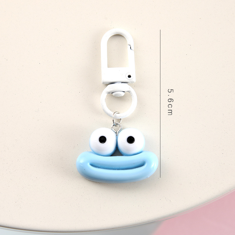 かわいいアニメの大きな口のキーホルダーは学生のカバンを飾っています。