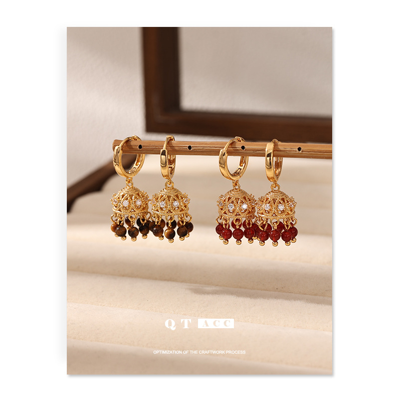 Europa y los Estados Unidos retro luces de palacio de viento aretes incrustados con zircon piedra de ojo de tigre rojo ágata brilla colgante otoño y invierno pernos