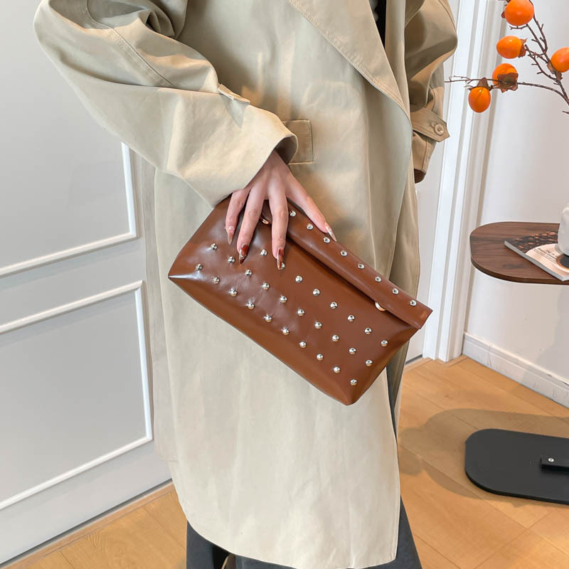 Niche bolsas de mano de gran capacidad de Europa y los Estados Unidos coreano 2025 nuevo bolso de hebilla de absorción de aire extranjero chica caliente sobre bolso de remachete de mujer