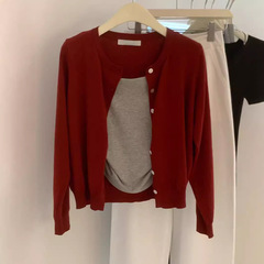 早秋の小柄な服装は赤い白い外着の美しいニットカーディガンの女性セーターのコートを着ています。