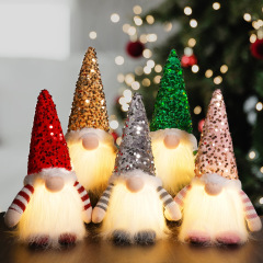 国境を越えたクリスマスの顔のない人形の装飾の明るい帽子は光ることができます。