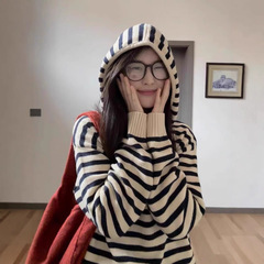 レトロな衝突色のストライプの半開襟ファスナーと帽子の外にニットのセーターを着ています。女性は秋冬にゆったりとした上着を着ています。