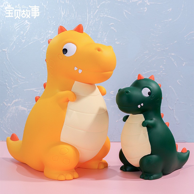 La decoración del hogar de la alcancía de los niños lindos de dibujos animados transfronterizos puede entrar y salir de la alcancía de dinosaurio resistente a la caída