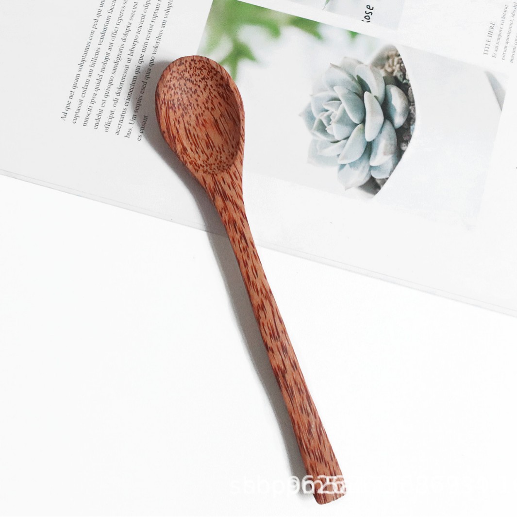 Tazón de coco natural estilo sudeste asiático, con cuchara y tenedor de madera, ideal para ensaladas o desayunos saludables