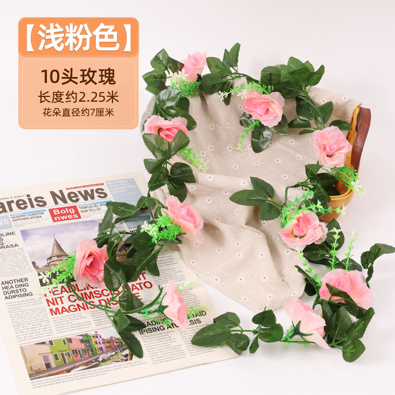 Simulación de flores falsas rosas de caña colgando la pared tubería de drenaje envuelta hoja verde que cubre la parte superior de la decoración de boda de plástico