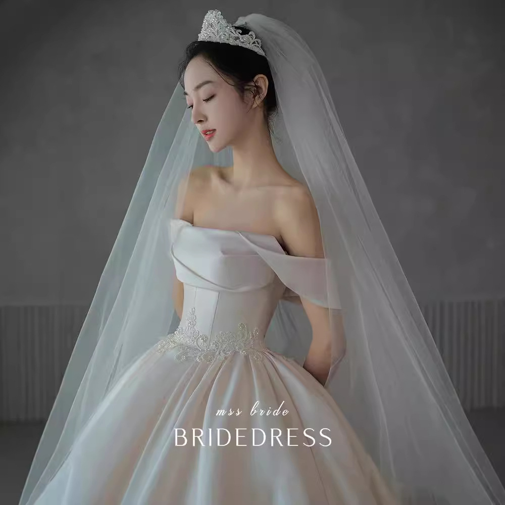 Vestido de novia principal al estilo de Gao Luo, nuevo modelo 2026, estilo retro francés de satén con hombros descubiertos para novias pequeñas, disponible para venta al por mayor.