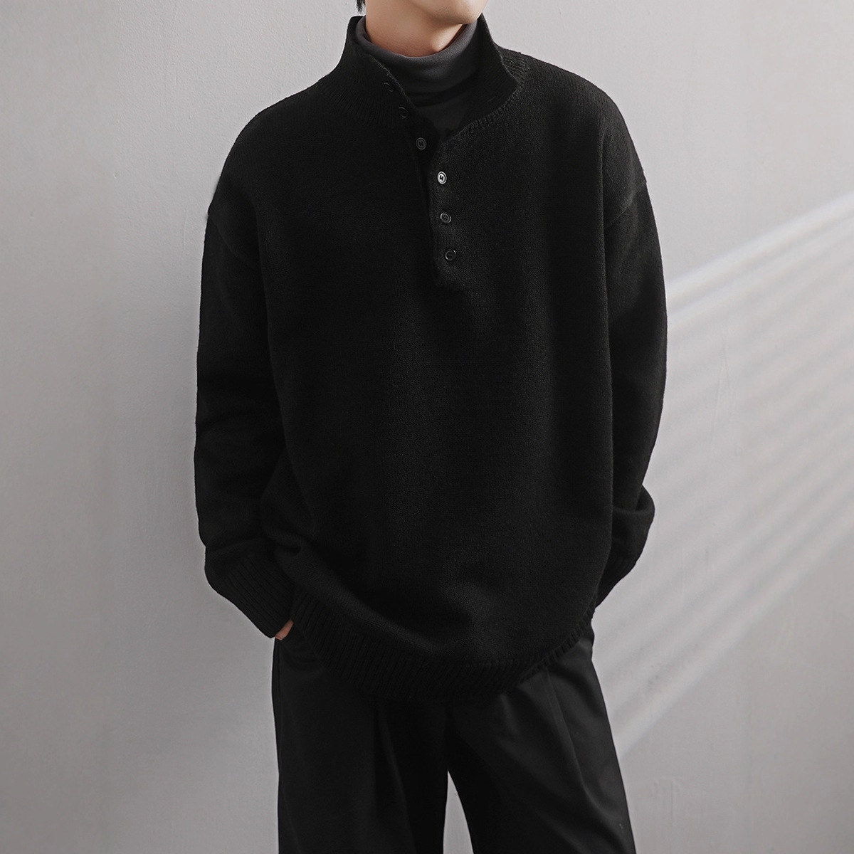 Medio cuello alto 2025, otoño y invierno, camiseta de punto de color sólido, diseño de cuello de botón, suéter de personalidad, chaqueta suelta para hombres