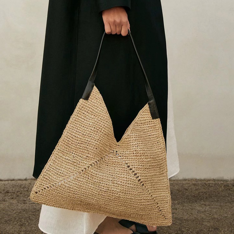 Instagram-Influencer mit dem gleichen Auto, das eine faltbare Handtasche aus Stroh mit einer Schulter, eine gewebte Tasche, einen Strandurlaub näht_voghion.com