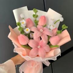 完成品の母の日にチューリップの花束をひねって、手に花を持って、手に花束を編んで、彼女に高級な贈り物をします。