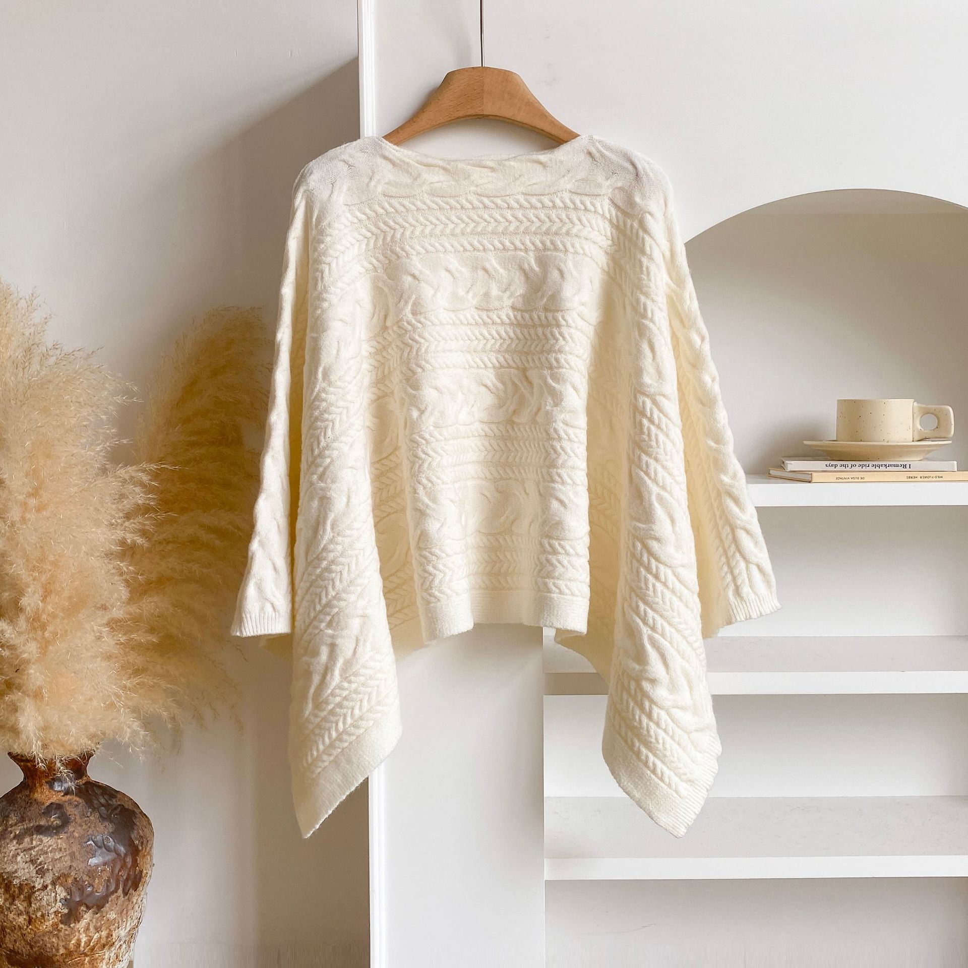 Wrap your ears and head up when you go out. This autumnal, cozy wool cape-style outerwear features a double-sided cable knit design