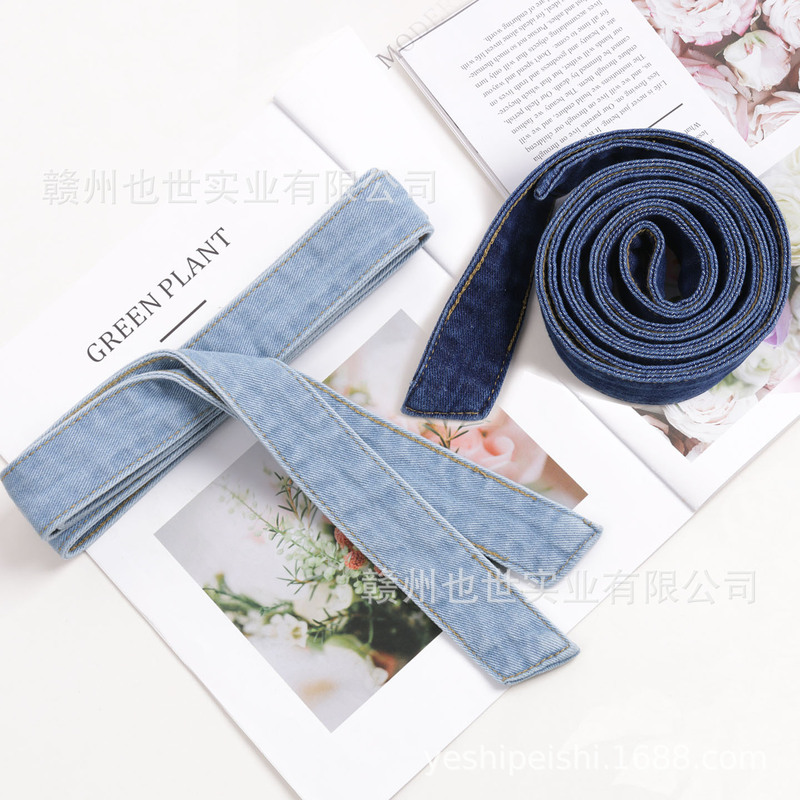 Denim belt paired with a dress jumpsuit, wide denim strap with bow tie, vintage blue-black color Denim belt paired with a dress jumpsuit, wide denim strap with bow tie, vintage blue-black color