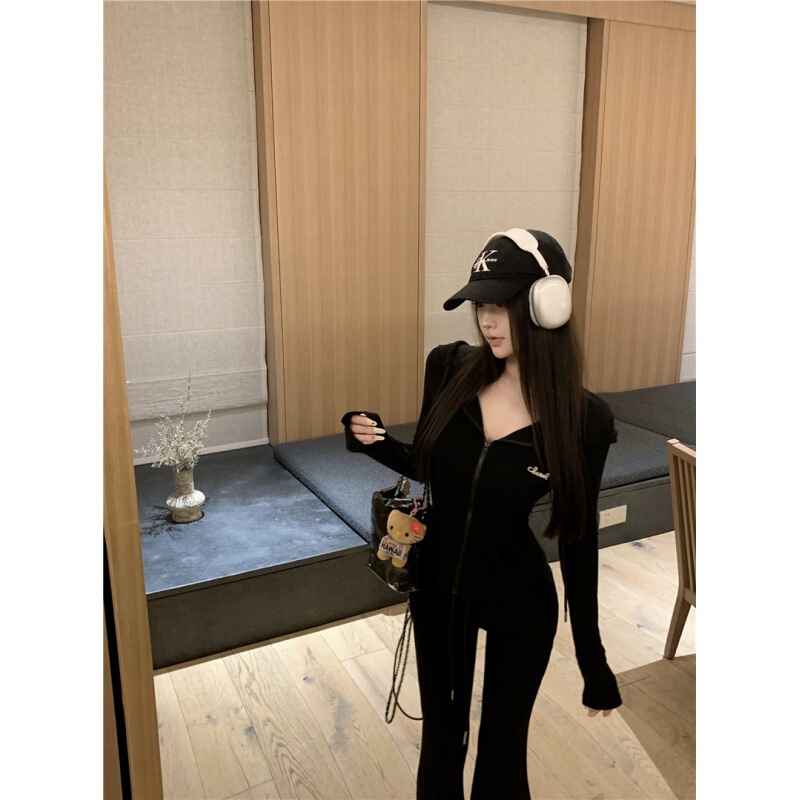 カジュアルスポーツスーツの女性は秋に帽子をかぶって腰のガードルのコートを着て、スピーカーでズボンを2セット持っています|undefined