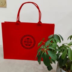 お土産袋のトートのプレゼントは透かし彫りの赤い喜字のフェルトの手提げ袋を包みます。