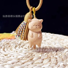 ケヤキの横になっている猫のカップルのキーホルダーに合わせて携帯電話を掛けて、無事にお金を募集します。