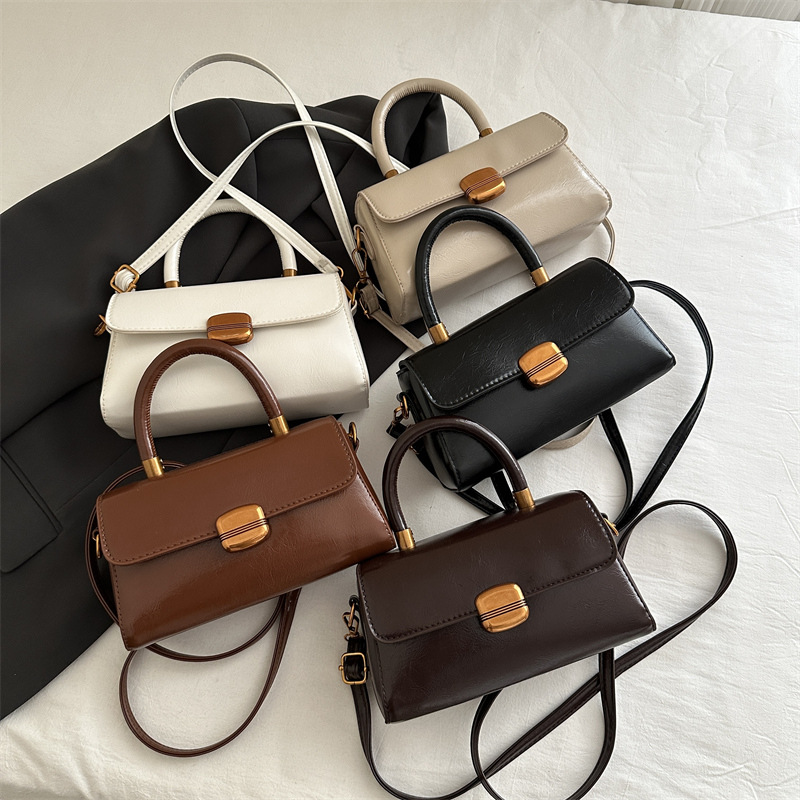 Nicho de diseño coreano bolso de mano 2025 primavera nuevo estilo simple de moda con cierre de flip de hombro monocolor bolso de mochila