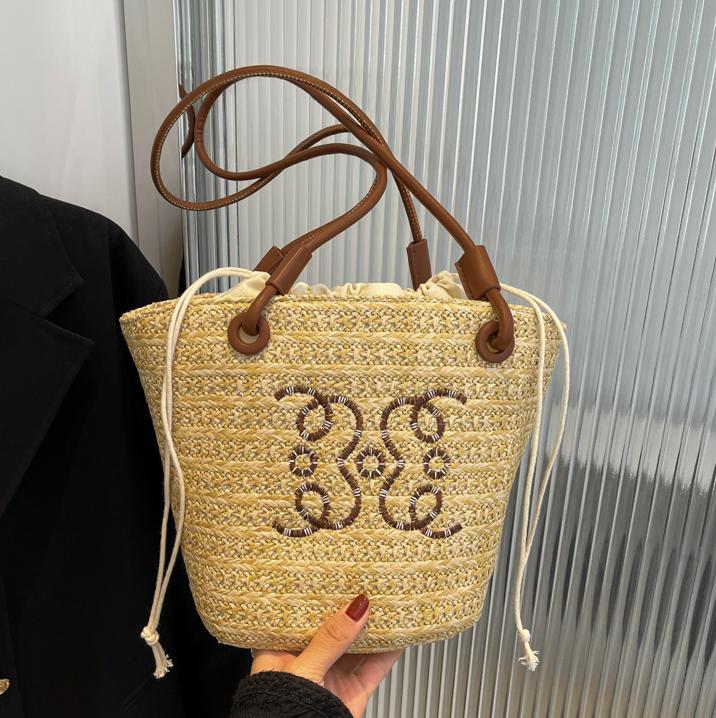 Bolsos tejidos populares de verano para damas 2025 nuevo bolso de cubo de moda de nicho de venta caliente bolso de hombro de estilo occidental de todo fósforo