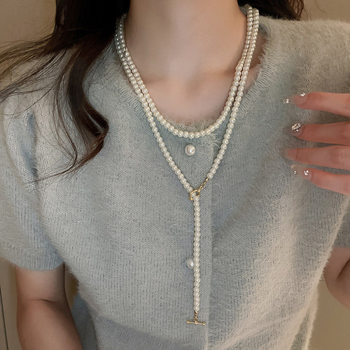 A high-end, diamond-embellished floral geometric pearl necklace with a light luxury vibe, sweater chain, French retro pendant accessory for autumn and winter.