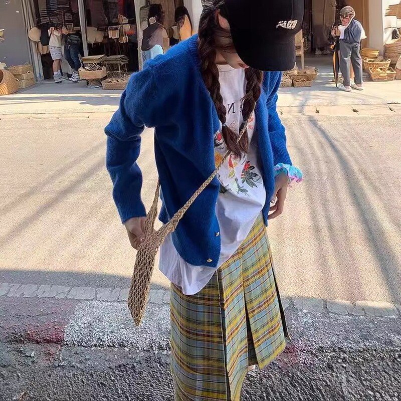 レトロで優しい風の小金はニットの女性のカーディガンを掛けます。|undefined