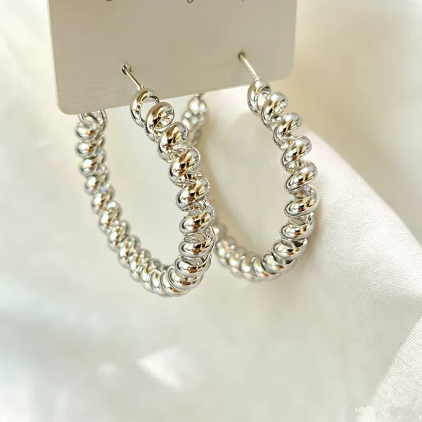Trendy spiral-patterned earrings, exuding a luxurious and sophisticated aura, featuring a high-quality silver texture, a unique design, and an irregular shape, making them a standout piece of jewelry for women