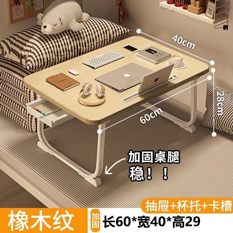 ベッドの上の小さい机のノートパソコンの机の上で折り畳みます。|undefined