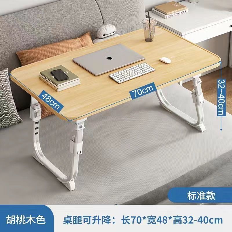 ベッドの上の小さい机のノートパソコンの机の上で折り畳みます。|undefined