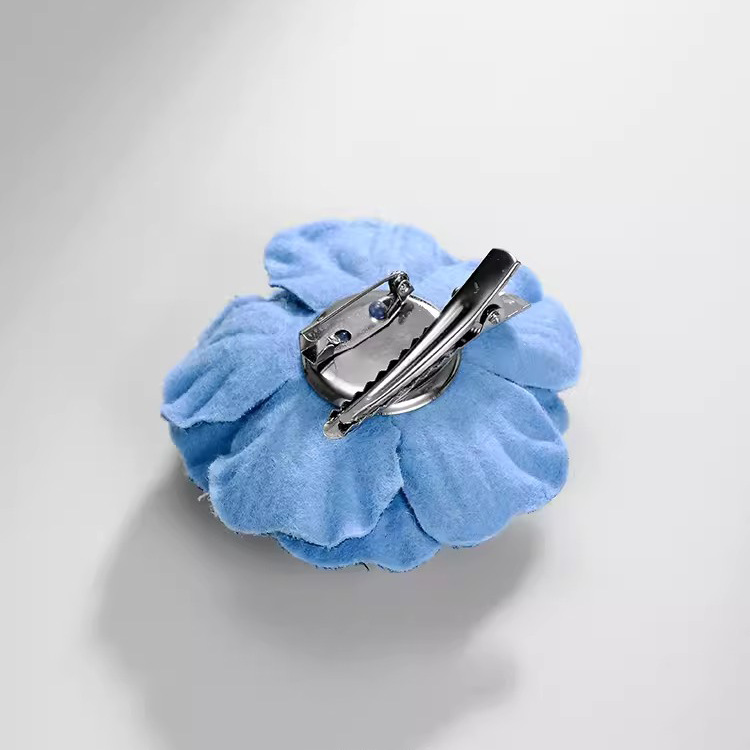 Vintage denim stoffen camelia broche, een elegant driedimensionaal accessoire voor dames._voghion.com