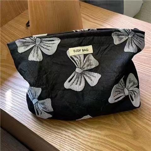 검은색 바탕에 회색 리본이 달린 화장품 가방