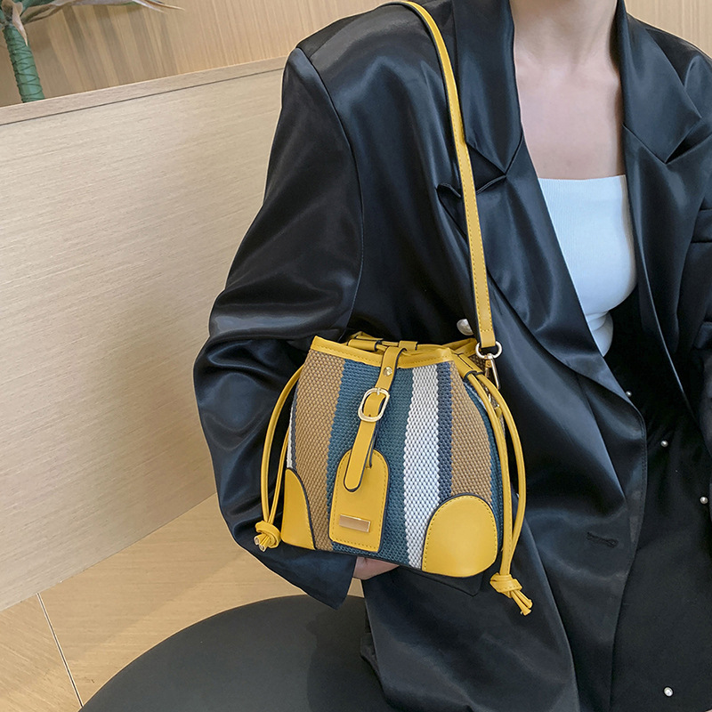Diseño de nicho de moda bolsa de cubo portátil para mujeres 2023 nueva moda lienzo contraste color rayas hombro bolsa de mensajero