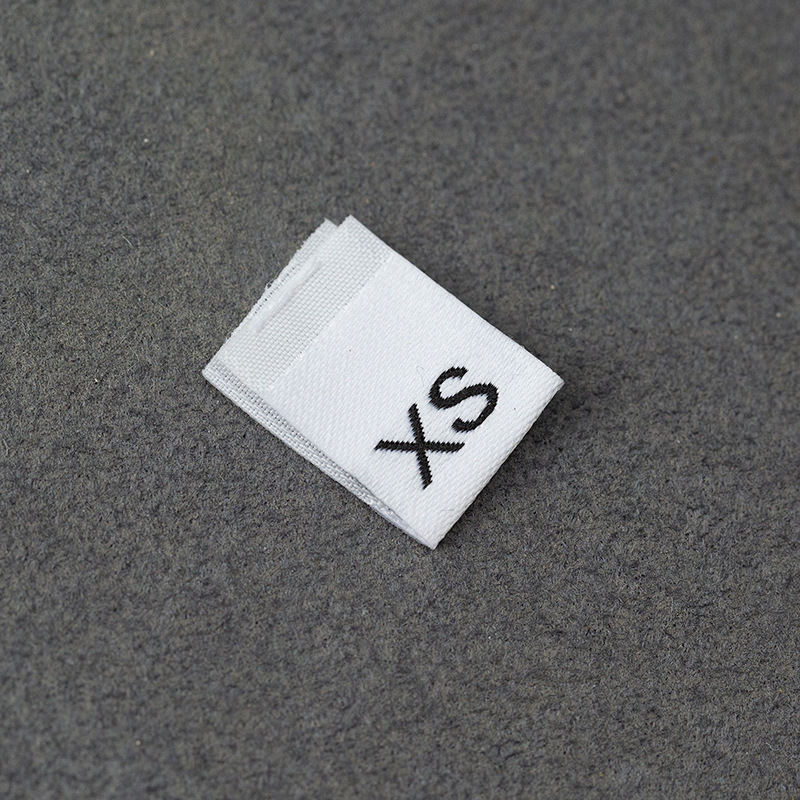 En stock Etiqueta de tamaño de alta densidad en blanco y negro Etiqueta de tamaño universal Etiqueta de código de letra inglesa Pantalones Etiqueta de código de cuello de camiseta