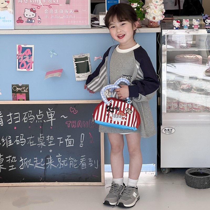 Versión coreana del popular bolso de hombro para niños y niñas, bolso de bebé semicircular a rayas de moda, nuevo bolso para niños con colgante