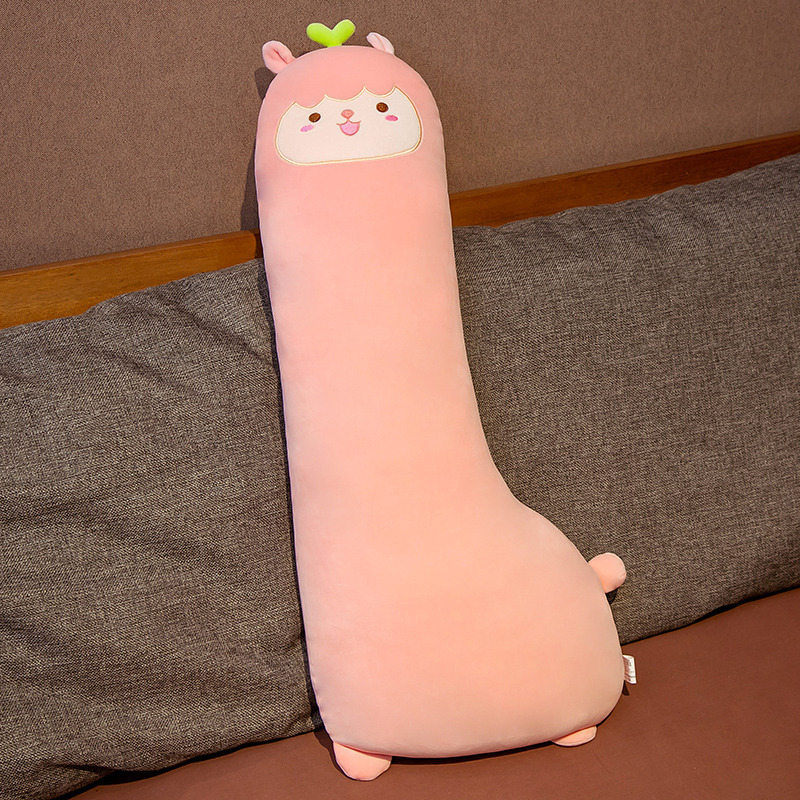 かわいい恐竜の長い抱き枕のぬいぐるみのベッドの上で女の子が寝ています。|undefined