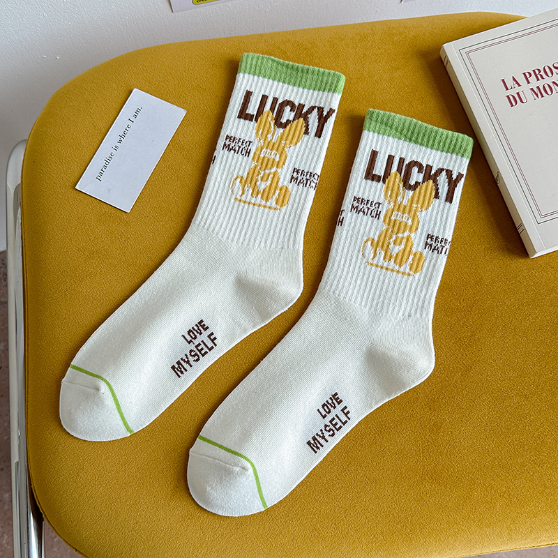 Calcetines de algodón de color puro Mediados de la pantorrilla de las mujeres Otoño e invierno Letras blancas Calcetines de marea de alta elástico Calcetines deportivos al por mayor