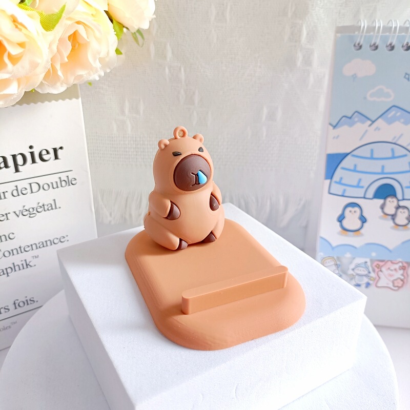 創意カピバラの子供の携帯電話のスタンドは携帯電話を並べてタブレットのデスクトップの棚に座って携帯します。|undefined