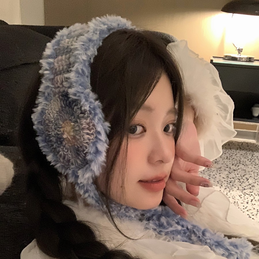ニットの毛糸の耳カバーの女性は冬の毛がふわふわしています。耳カバーを厚くして保温しています。