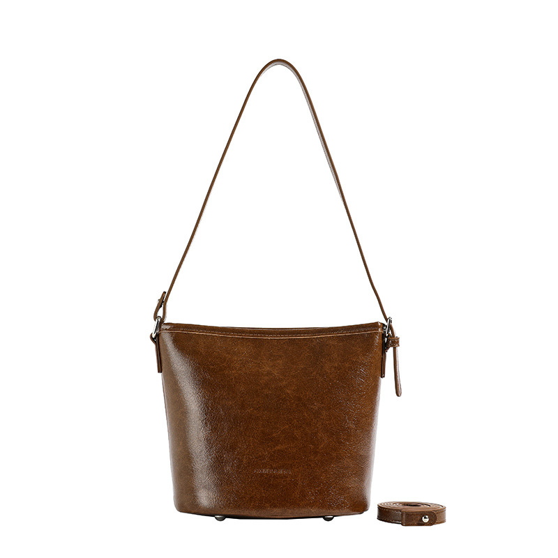 Bolsos de mano retro de alta textura para mujeres 2025, nuevos bolsos de hombro de moda simples, bolsos de cubo de transporte universal