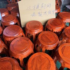 赤い木の太鼓の腰掛けは古木の丸い腰掛けをまねます。