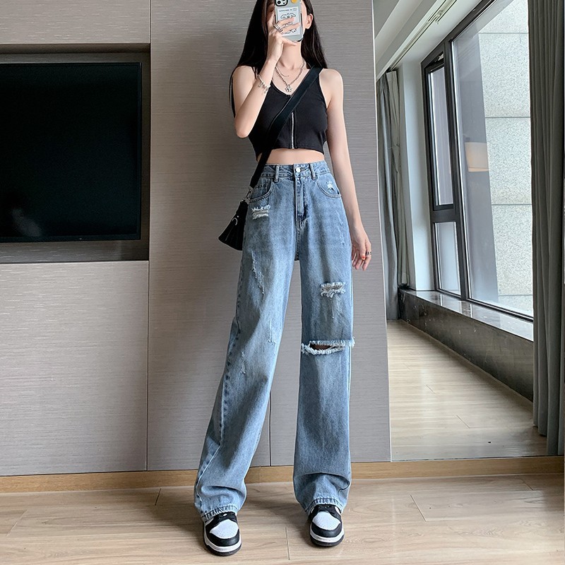 やせて穴が開いているジーンズの女性は腰が高くてゆったりしています。|undefined