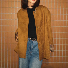 豹が歩いている女性の茶色のスエードの質感は豹の紋様のプリントをつなぎ合わせて重ねて襟の形のコートのジャケットの上着を着ます。