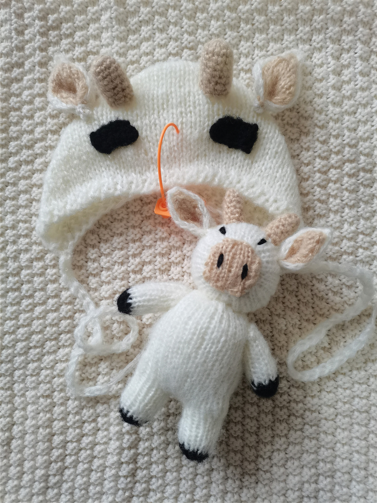 子供の写真を撮る服の影楼の赤ちゃんはいっぱいで毛糸の子牛の造形の帽子の人形を撮影します 日本産