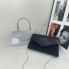 国境を越えて封筒をひっくり返して、女性用の輝くパーティーのハンドバッグを手に入れます。