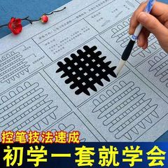 初心者の子供の学生は筆を制御して筆の書道の入門を訓練します。