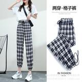 Эластичные черно -белые брюки клетку ткане