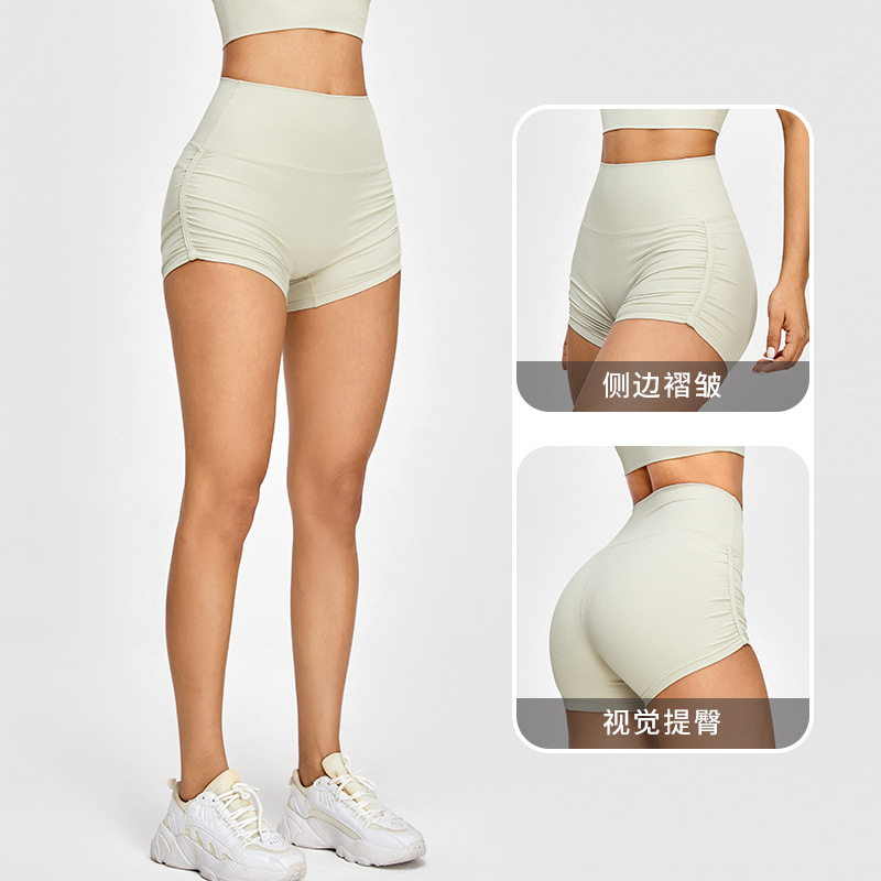 Pantalones cortos deportivos de levantamiento de cadera de melocotón europeo y americano Pantalones cortos de fitness ajustados plisados de mujer Ropa de fitness de secado rápido Pantalones cortos de Yoga de tres puntos
