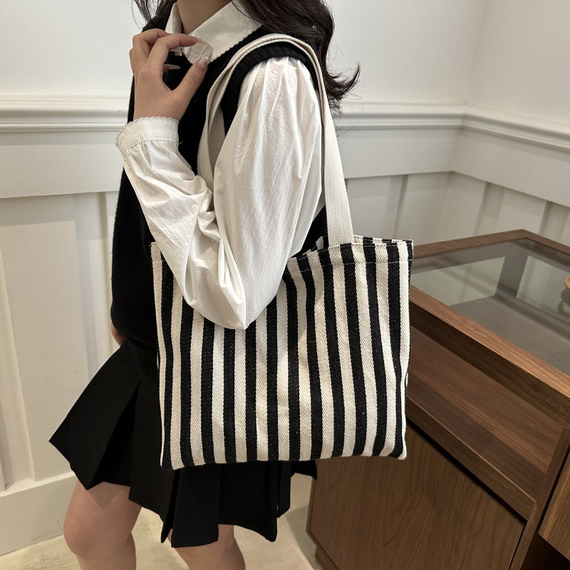 The new cross-border vertical striped commuter tote bag, hand-held shoulder bag, is fashionable and has a large capacity. It features an InS-style simple letter sail undefined