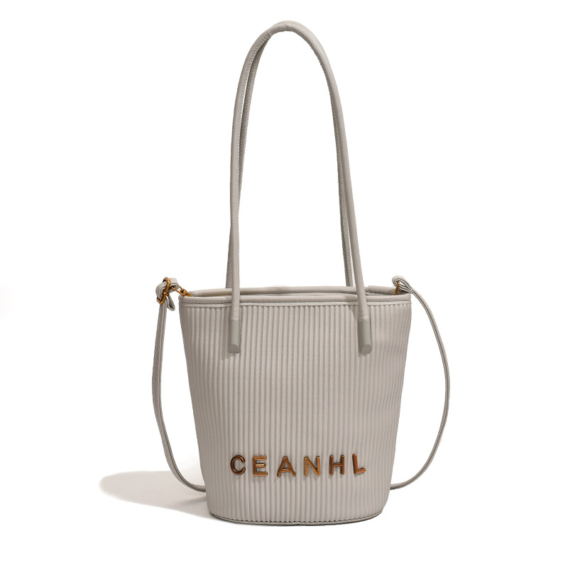 2025 otoño y invierno nuevo pequeño bolso a rayas de viento fragante bolso de cubo simple bolso de hombro de tendencia de mujeres bolso de mochila popular