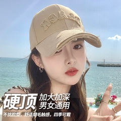ハードトップの野球帽の女性は穴を開けて古いことをして、大きい頭の周りを深くして顔を見せます。