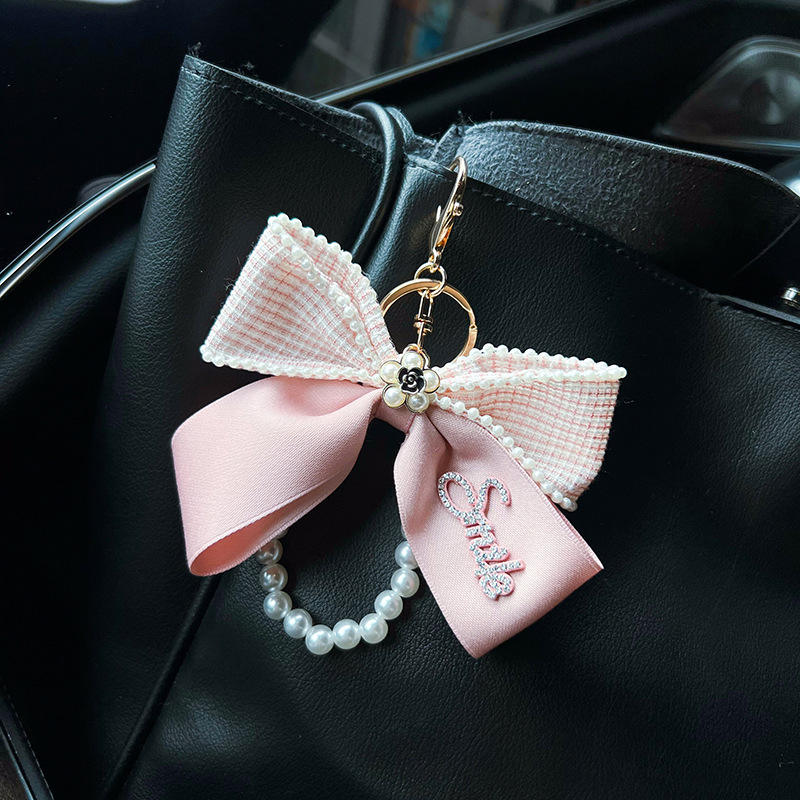 Nuevo Xiaofeng Shan camellia letra arco llavero de automóvil cadena de perlas bolsos creativos decoración colgante mujer