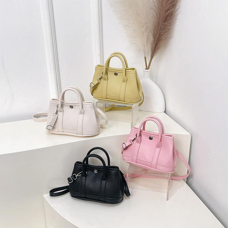 2025 estilo coreano nuevo nicho simple ocio viaje bolsa de cubo portátil diseño de lichi bolso de mochila de color sólido mujer